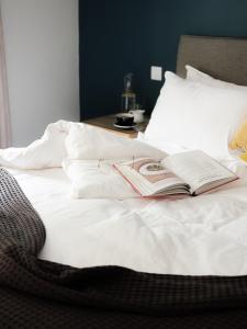 a book laying on top of a white bed at The Stump in Cirencester