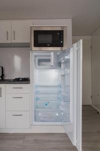 an empty refrigerator with its door open in a kitchen at Hausboat Erik in Hrdoňov