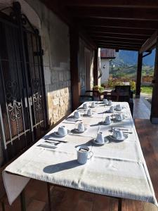 un lungo tavolo con tazze e piattini sopra di Casale San Felice B&B a Cusano Mutri