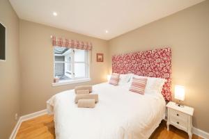 a bedroom with a large white bed with a red headboard at Strathallan - Luxury 3 Bedroom Apartment, Gleneagles, Auchterarder in Auchterarder
