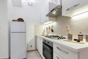 eine weiße Küche mit einem Herd und einem Kühlschrank in der Unterkunft Kalinifta - Jacuzzi & Suites SIT in Lecce