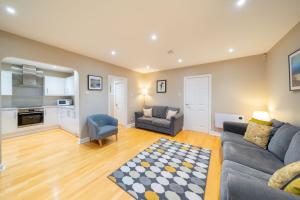 a living room with a couch and a chair at Strathallan - Luxury 3 Bedroom Apartment, Gleneagles, Auchterarder in Auchterarder