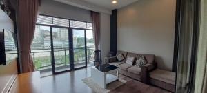 a living room with a couch and a large window at aparthotel cameron in Brinchang