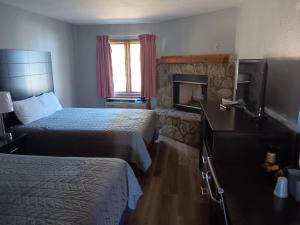 a hotel room with two beds and a fireplace at Hofbrau Riverfront Hotel in Helen