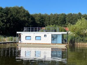 una casa flotante en un muelle sobre un cuerpo de agua en Hausboat Erik, en Hrdoňov