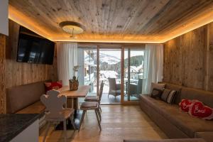 a living room with a couch and a table at Hotel Ciasa Soleil in La Villa