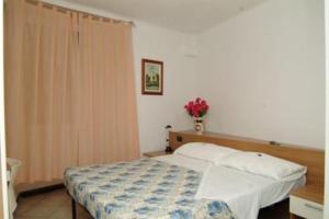 a bedroom with a bed and a vase of flowers at Hotel Acquario in Genova