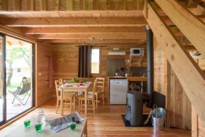 a kitchen and dining room of a log cabin at Huttopia Font Romeu in Font-Romeu