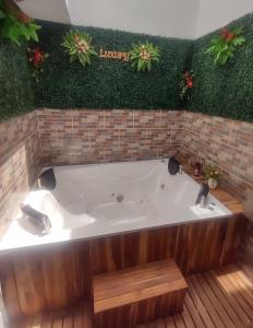 - une grande baignoire dans une pièce ornée de plantes dans l'établissement Casa Vacacional con Jacuzzi en Girardot Cundinamarca, à Girardot