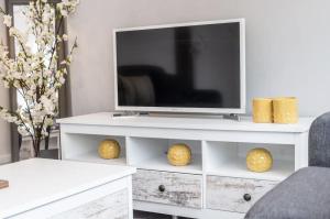 ein Wohnzimmer mit einem TV auf einem weißen Entertainment-Center in der Unterkunft Liverpool TownHouse in Liverpool