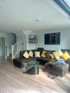 a living room with a couch and a table at Modern Cotswold Home w Hot Tub in South Cerney