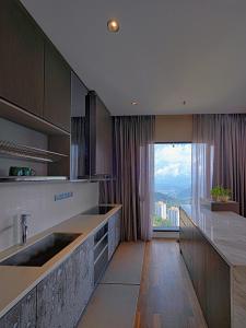 uma cozinha com um lavatório e uma grande janela em Geo38 Genting 3Bed2Bath 10 pax High Floor Free WiFi em Genting Highlands