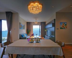 uma sala de estar com uma mesa e um lustre em Geo38 Genting 3Bed2Bath 10 pax High Floor Free WiFi em Genting Highlands