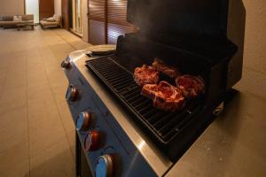a stove with meat cooking on a grill at Santa Lucia - Villa&Boat in Turanj