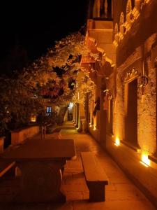 zaułek w nocy z dwoma ławkami przed budynkiem w obiekcie Mozaik Stone Hotel w mieście Avanos