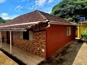 ein kleines rotes Backsteinhaus mit einem Dach in der Unterkunft Casinha da Vovó in São Lourenço