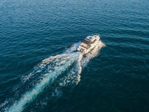 a boat in the water in the ocean at Santa Lucia - Villa&Boat in Turanj