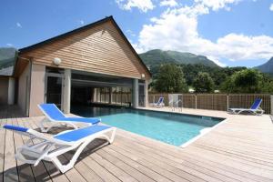a swimming pool with two chairs and a deck at Appartement V de ROLAND Luz VDR212 in Luz-Saint-Sauveur