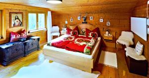 ein Schlafzimmer mit einem roten Bett in einem Holzzimmer in der Unterkunft Walserhaus in Brand