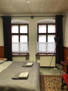 1 Schlafzimmer mit 2 Fenstern und 1 Bett mit 2 Handtüchern in der Unterkunft Apartman U Andela in Strakonice