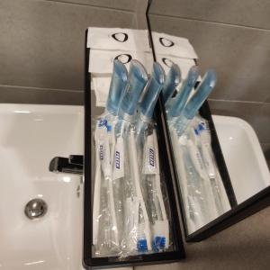 Zahnbürsten in Plastiksäcken neben einem Waschbecken in der Unterkunft Urban Suites Jsw in Jelutong