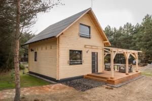 a tiny house with a porch and a deck at Ostoja Notecka in Wieleń