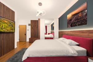 um quarto com uma cama grande e um sofá vermelho em Pitesti Residence em Piteşti