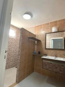 a bathroom with a sink and a mirror at Maison Les Oliviers avec piscine proche du lagon in Taguermess