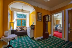 un soggiorno con pareti gialle e divano di Woodlands Bed and Breakfast a Dornoch