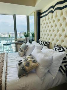 een slaapkamer met een groot bed met kussens bij Azure Urban Resort - St Tropez Tower Staycation Unit with a European Touch in Manilla