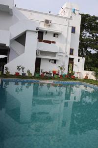 una casa y una piscina frente a un edificio en Royal Experience Marhaba Villa Nest, en Mahabalipuram