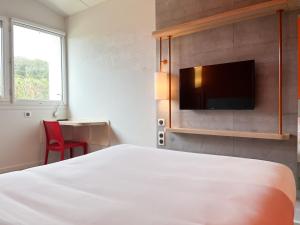 una camera con letto e TV a schermo piatto di Ibis Budget Saint Christol Les Alès a Saint-Christol-lès-Alès