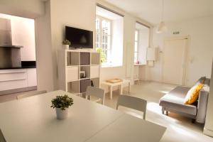 a white living room with a table and a couch at Saint Thomas 2 - Joli T2 dans Strasbourg in Strasbourg