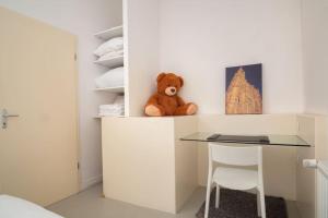 um urso de peluche sentado em cima de uma secretária num quarto em Saint-Thomas 2 - Joli T2 dans Strasbourg em Estrasburgo