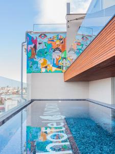 - une fresque murale sur le côté d'un bâtiment avec piscine dans l'établissement Hotel Indigo Madrid - Gran Via, an IHG Hotel, à Madrid