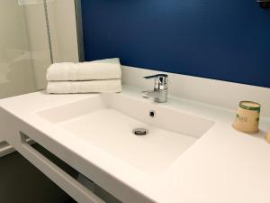 a bathroom with a white sink and a blue wall at Ibis Budget Saint Christol Les Alès in Saint-Christol-lès-Alès +52 photos