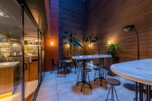 a restaurant with tables and stools in a room at Hotel Indigo Madrid - Gran Via, an IHG Hotel in Madrid