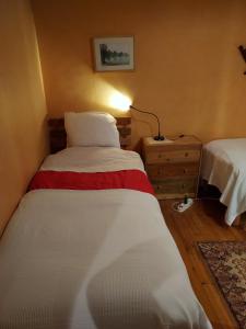 ein kleines Schlafzimmer mit 2 Betten und einer Lampe in der Unterkunft Bn'B Juno Beach 5' de la plage ! in Bernières-sur-Mer
