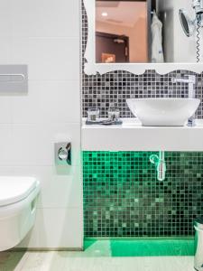 a bathroom with a sink and a toilet and a mirror at Hotel Indigo Madrid - Gran Vía by IHG in Madrid