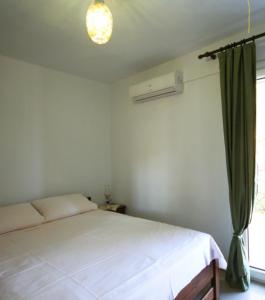 a bedroom with a white bed and a window at Ktima Apostolou in Aspropótamos