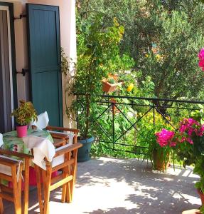un porche con una puerta, un banco y flores en Ktima Apostolou, en Aspropótamos