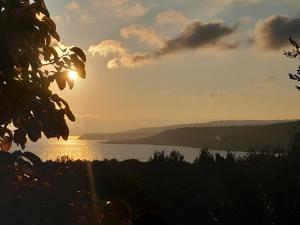 a sunset over a body of water with mountains at Ktima Apostolou in Aspropótamos