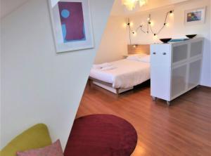 a bedroom with a bed and a dresser in a room at Mésange - Studio au centre de Strasbourg in Strasbourg