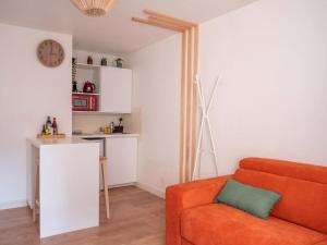 sala de estar con sofá naranja y cocina en Le Phalsbourg - Escapade citadine à Strasbourg en Estrasburgo