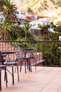 a group of chairs and tables on a balcony at Tamahuche Hotel Rural in Vallehermoso