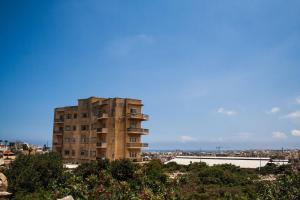 um edifício de apartamentos alto em frente a uma cidade em Spacious modernist Apt with views & pool em Tal-Mejda