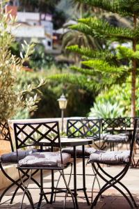 a group of chairs and a table in a garden at Tamahuche Hotel Rural in Vallehermoso