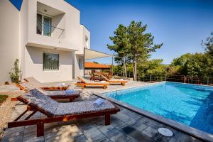 una villa con piscina y una casa en Modern villa with pool, whirpool in quiet area - by Traveler tourist agency Krk ID 2180, en Gostinjac