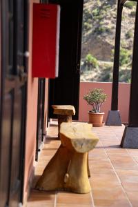 a wooden bench sitting on the side of a building at Tamahuche Hotel Rural in Vallehermoso