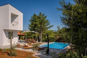 una piscina en el patio trasero de una casa en Modern villa with pool, whirpool in quiet area - by Traveler tourist agency Krk ID 2180, en Gostinjac